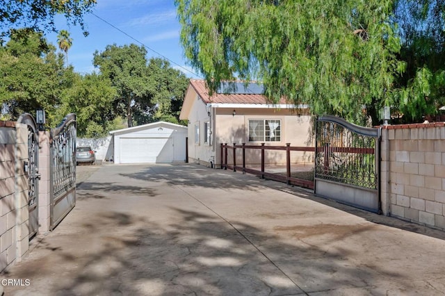 view of side of home with a gate, fence, an outdoor structure, and stucco siding