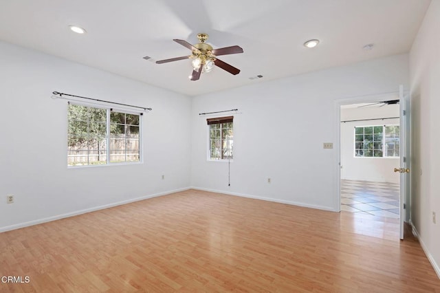 spare room featuring light wood-style floors, plenty of natural light, a ceiling fan, and recessed lighting