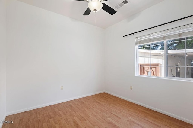 spare room featuring light wood-style floors, baseboards, and visible vents