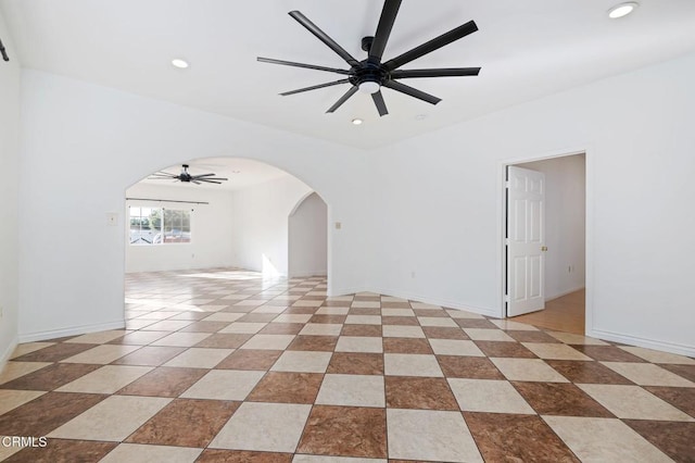 spare room with a ceiling fan, arched walkways, baseboards, and recessed lighting