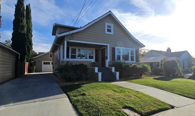 view of front of property featuring a garage, a front lawn, and an outbuilding