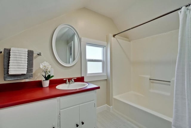 bathroom with lofted ceiling, vanity, and shower / bath combo