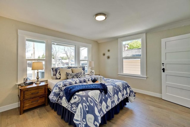 bedroom with multiple windows and light wood-type flooring