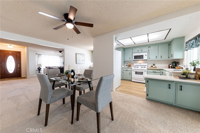 carpeted dining space featuring ceiling fan, sink, and a textured ceiling