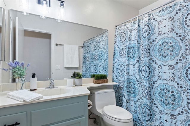 bathroom with toilet, vanity, and walk in shower