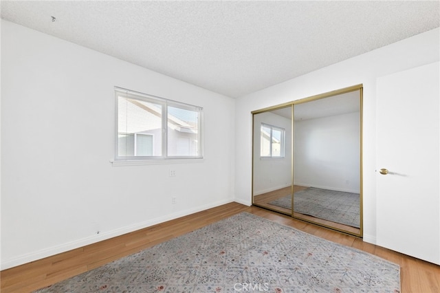 bedroom featuring hardwood / wood-style floors, a closet, and a textured ceiling