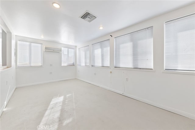 unfurnished room featuring an AC wall unit