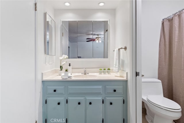 bathroom featuring toilet, vanity, walk in shower, and ceiling fan