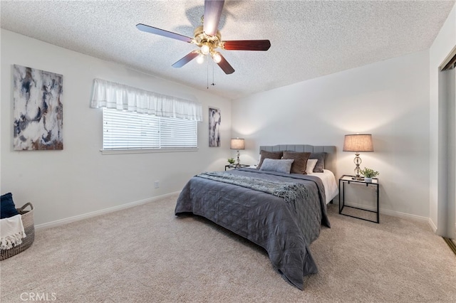 carpeted bedroom featuring ceiling fan and a textured ceiling