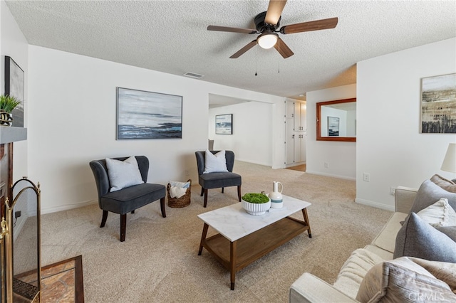 living room featuring a textured ceiling, ceiling fan, and light colored carpet