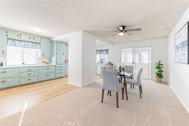 dining space with a wealth of natural light, ceiling fan, and a textured ceiling