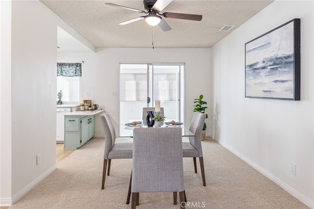 dining area featuring plenty of natural light, a textured ceiling, and light colored carpet