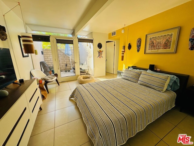 tiled bedroom with access to exterior and beamed ceiling