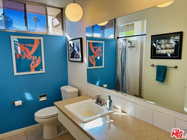 bathroom with a shower with shower curtain, toilet, sink, and tile patterned floors