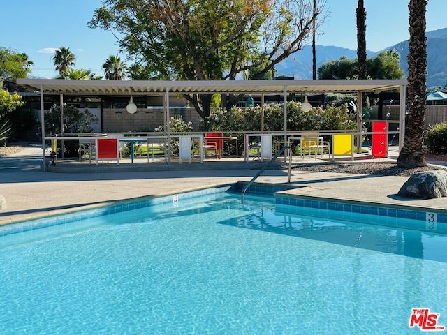 view of pool featuring a mountain view and a patio