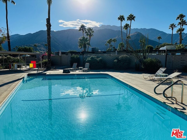 view of swimming pool with a mountain view and a patio area