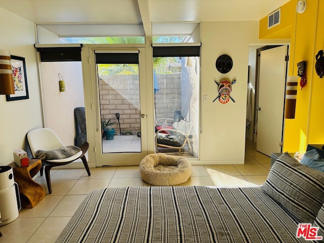 doorway featuring beamed ceiling and light tile patterned flooring