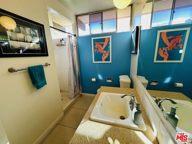 bathroom with tile patterned flooring, a shower with curtain, toilet, and sink