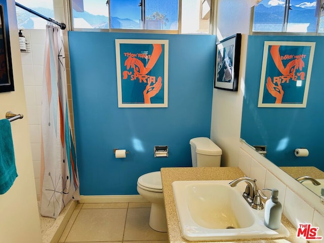 bathroom with a wealth of natural light, sink, tile patterned flooring, and toilet