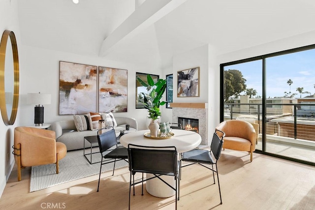 dining area featuring a glass covered fireplace and light wood-style flooring