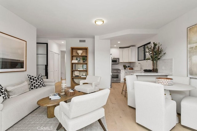 living area with recessed lighting, visible vents, and light wood-type flooring