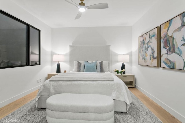 bedroom with ceiling fan, baseboards, and wood finished floors