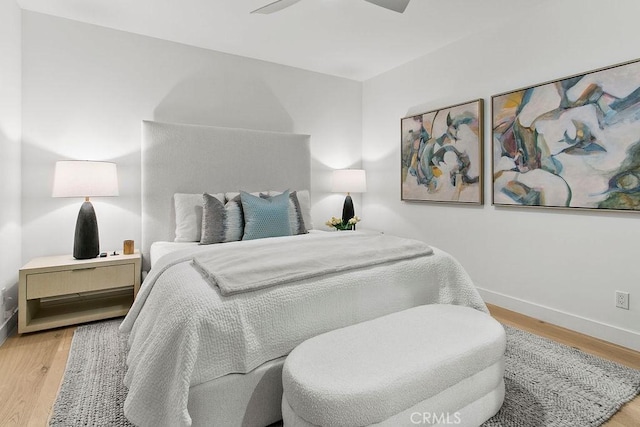 bedroom featuring ceiling fan, baseboards, and wood finished floors