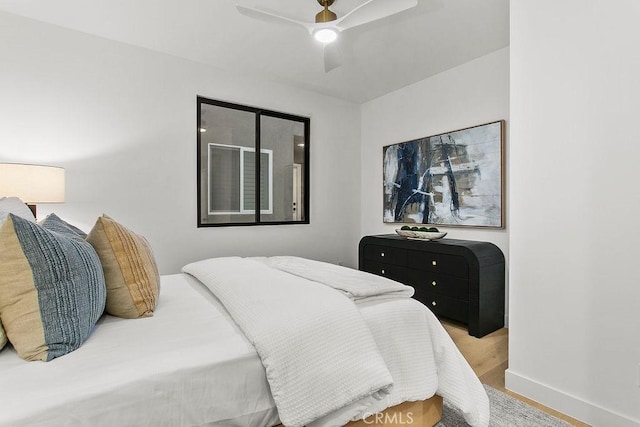 bedroom featuring baseboards, a ceiling fan, and wood finished floors