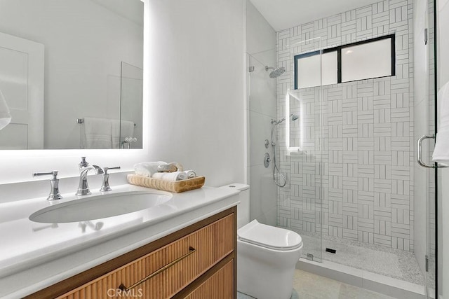 bathroom with toilet, a stall shower, and vanity