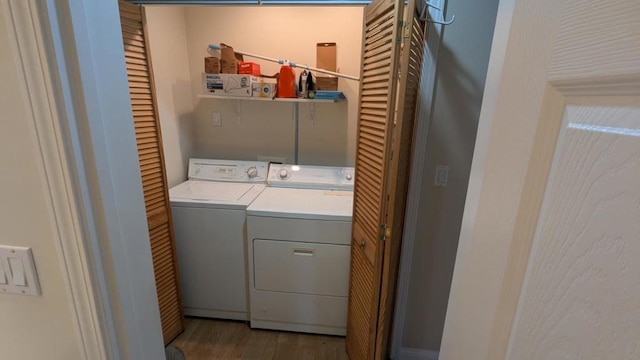 clothes washing area featuring washer and dryer and wood-type flooring