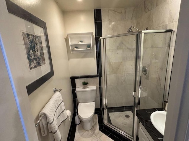 bathroom featuring a shower with shower door, toilet, vanity, and tile patterned flooring