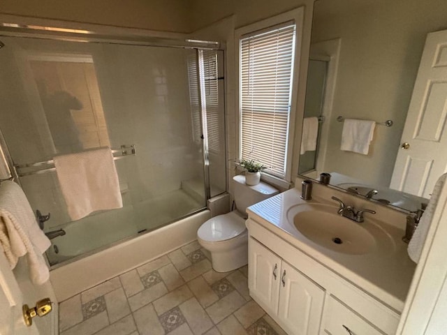 full bathroom featuring toilet, vanity, and shower / bath combination with glass door