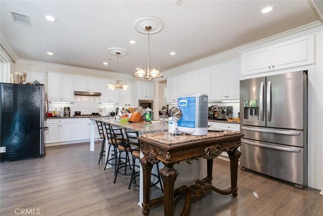 kitchen featuring white cabinets, ornamental molding, stainless steel appliances, and dark wood-type flooring