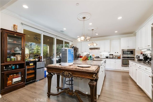 kitchen with pendant lighting, white cabinets, appliances with stainless steel finishes, and dark stone counters