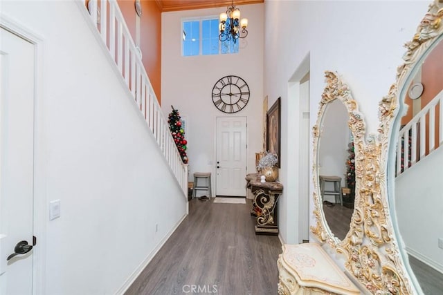 foyer entrance with dark hardwood / wood-style flooring, an inviting chandelier, and ornamental molding