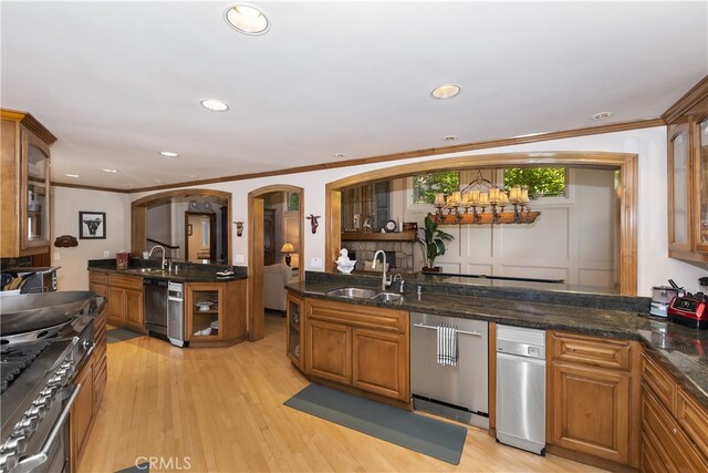 kitchen with sink, ornamental molding, stainless steel appliances, and light hardwood / wood-style flooring