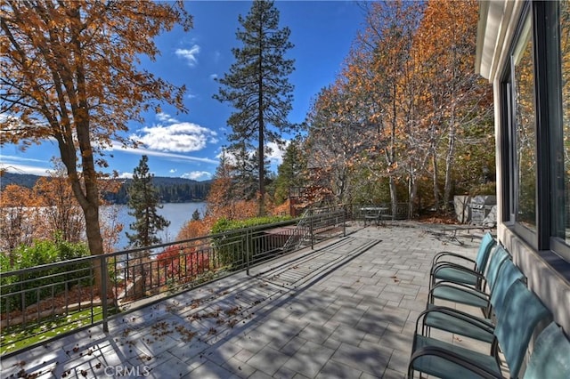 wooden terrace with a water view and a patio