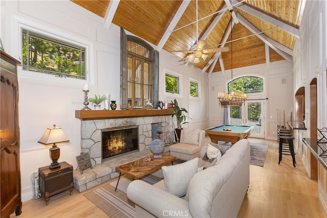 sunroom featuring pool table, a stone fireplace, vaulted ceiling with beams, ceiling fan, and wooden ceiling