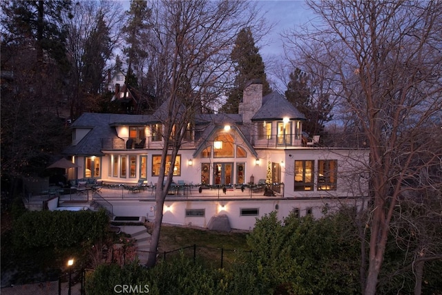 back of property with a balcony and a patio