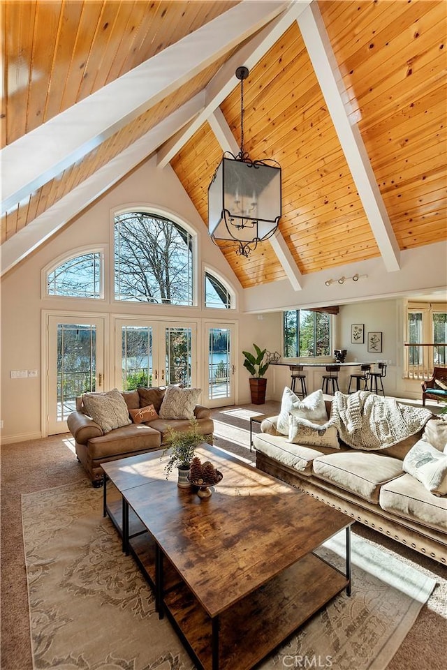 living room with a chandelier, carpet flooring, high vaulted ceiling, wooden ceiling, and beam ceiling