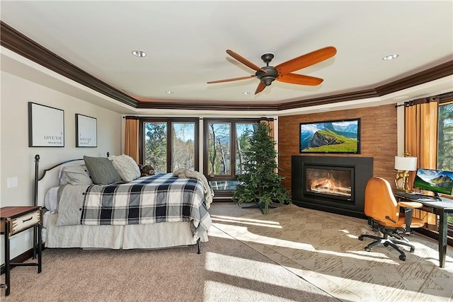 bedroom featuring ceiling fan, light carpet, crown molding, and a tray ceiling