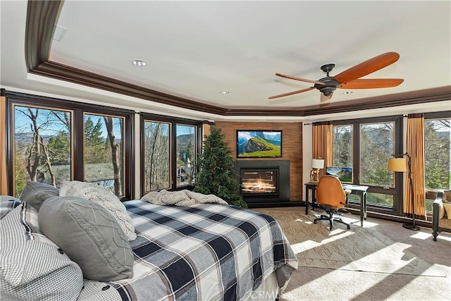 bedroom with ceiling fan, multiple windows, ornamental molding, and a raised ceiling