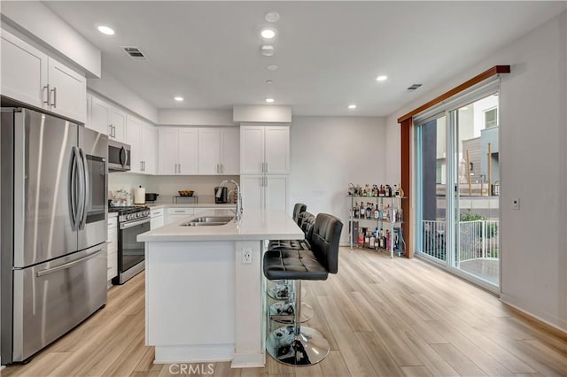 kitchen featuring white cabinetry, sink, stainless steel appliances, and plenty of natural light