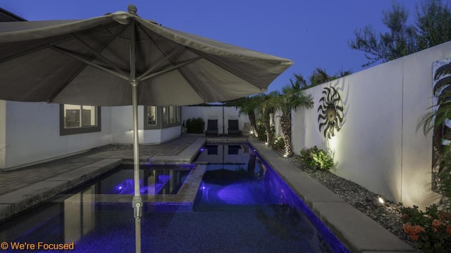 view of swimming pool featuring a patio area and an in ground hot tub