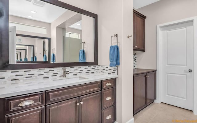 bathroom with tile patterned flooring, vanity, and tasteful backsplash