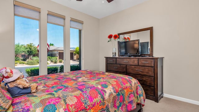 bedroom featuring ceiling fan, light carpet, and multiple windows