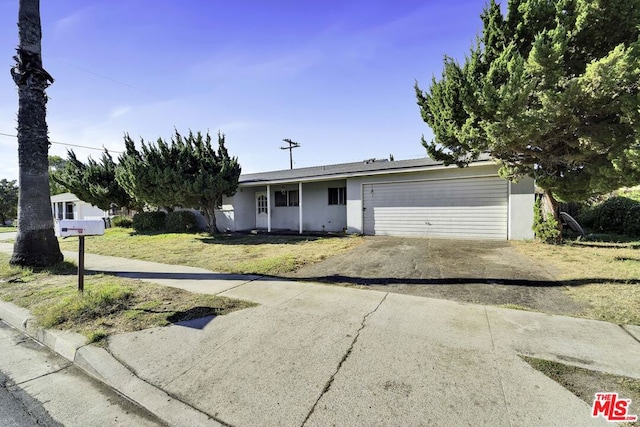 single story home featuring a garage and a front lawn