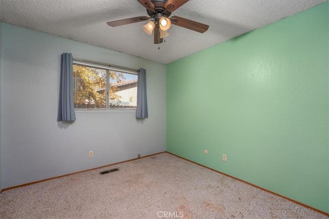 carpeted empty room with ceiling fan and a textured ceiling