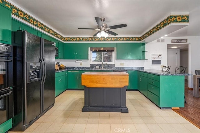 kitchen with black appliances, a center island, green cabinets, and sink