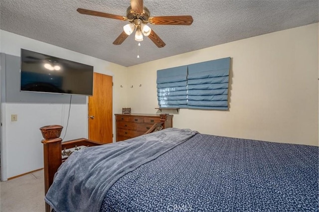 carpeted bedroom with ceiling fan and a textured ceiling